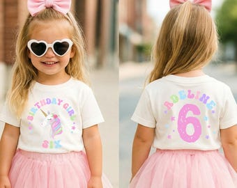 May include: A young girl wearing a white t-shirt with a unicorn graphic and the text "Birthday Girl Six". She is also wearing a pink tutu, heart-shaped sunglasses, and a pink bow in her hair. The back of the shirt says "Adeline 6".