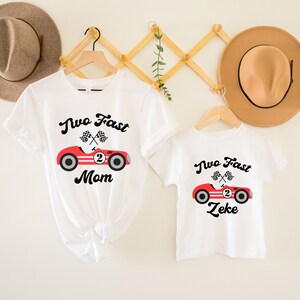 May include: Two white t-shirts with a red race car graphic and the text "Two Fast" and either "Mom" or "Zeke".