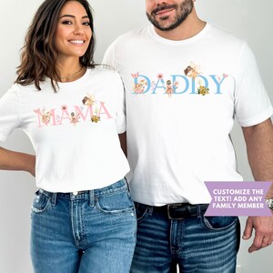 May include: Two white short-sleeved t-shirts featuring graphic designs. One shirt displays the pink text MAMA with fairy and floral illustrations. The other shirt displays the blue text DADDY with fairy and floral illustrations. A purple banner reads CUSTOMIZE THE TEXT! ADD ANY FAMILY MEMBER.
