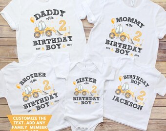 Peut inclure: Plusieurs t-shirts blancs et un body assorti, imprimés avec un motif commun pour un anniversaire. Chaque vêtement présente un engin de chantier jaune, le chiffre 2, et les mots "Daddy", "Mommy", "Brother", "Sister" et "Birthday Boy". Le texte "EST BOY 2024" est également inclus.