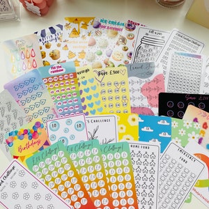 May include: A collection of colourful printable stickers for saving money. The stickers feature various themes, including birthdays, travel, home fund, emergency fund, and more. Each sticker has a grid of circles to track savings goals.