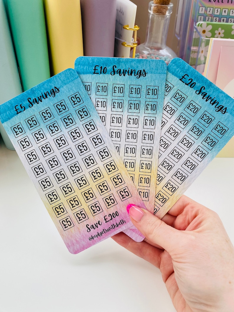 May include: Three colorful cards with a watercolor background. Each card has a different amount of squares with the text "&pound;5", "&pound;10", or "&pound;20" printed inside. The cards are labeled "&pound;5 Savings", "&pound;10 Savings", and "&pound;20 Savings". The bottom of the card reads "Save &pound;200 @budgetswithbeth".