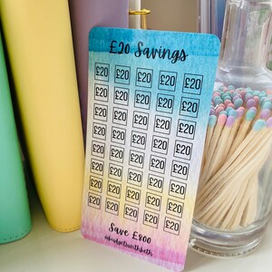 May include: A colorful card with a watercolor background and a grid of squares. Each square contains the text "&pound;20". The card has the text "&pound;20 Savings" at the top and "Save &pound;800 @budgetswithbeth" at the bottom.