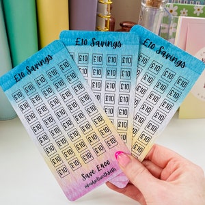 May include: Four colorful cards with a watercolor background and the text "&pound;10 Savings" printed on each card. Each card has a grid of 40 squares with the text "&pound;10" printed in each square. The cards are stacked on top of each other and the bottom card has the text "Save &pound;400" and "@budgetswithbeth" printed on it.
