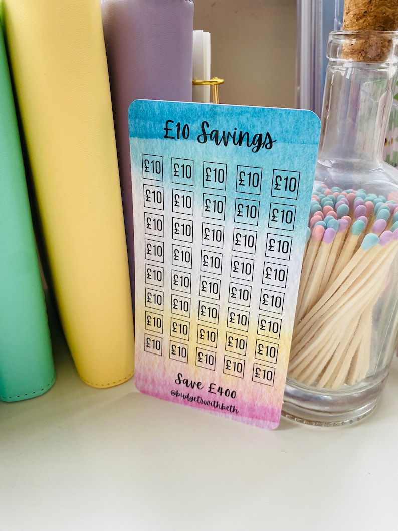 May include: A colorful card with a rainbow gradient background and the text "&pound;10 Savings" at the top. The card is divided into 40 squares, each containing the text "&pound;10". The bottom of the card reads "Save &pound;400" and "@budgetswithbeth".