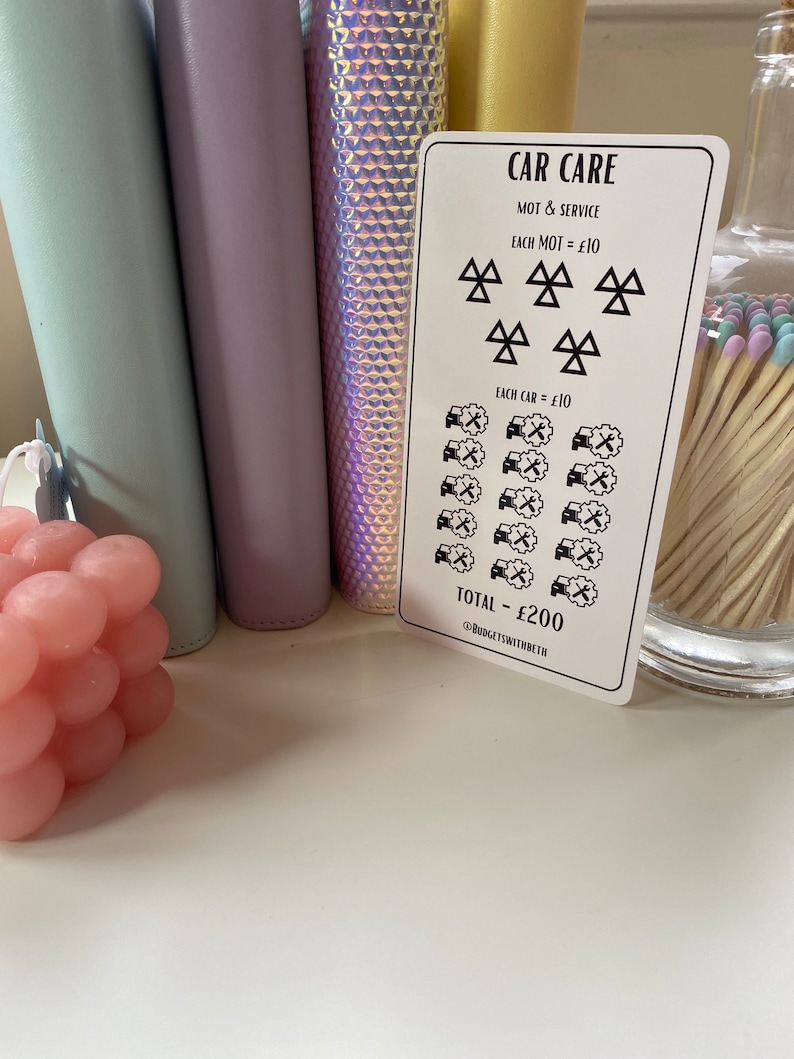 May include: A white card with black text and symbols outlining the cost of car care. The card reads "CAR CARE", "MOT & SERVICE", "EACH MOT = &pound;10", "EACH CAR = &pound;10", and "TOTAL - &pound;200". The card also includes a symbol for a car with a wrench and a symbol for an MOT test.