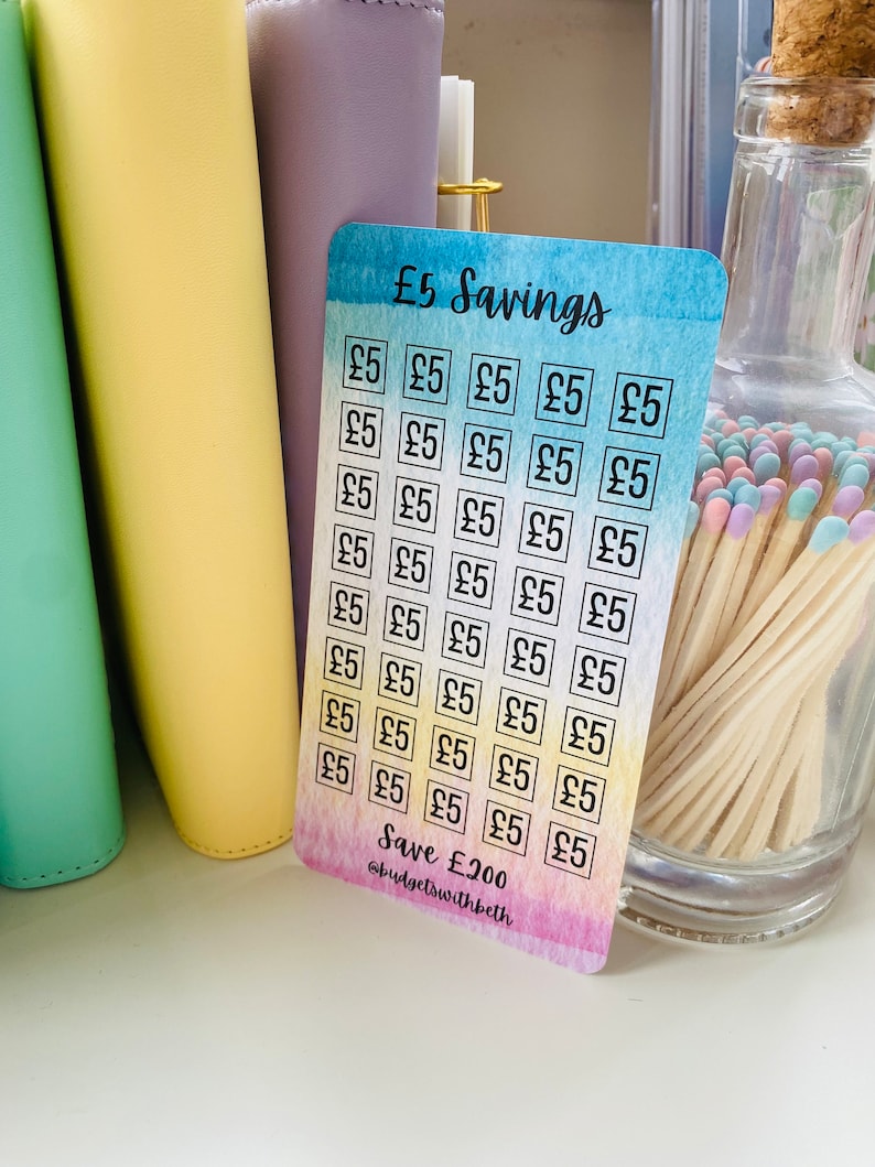 May include: A colorful card with a watercolor background and a grid of 25 squares. Each square contains the text "&pound;5" and the card says "&pound;5 Savings" at the top and "Save &pound;200 @budgetswithbeth" at the bottom.