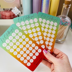May include: Three colourful cards with a gradient background and white circles with the text "£5", "£10", and "£20" printed on them. The cards are labelled "£5 Challenge", "£10 Challenge", and "£20 Challenge".