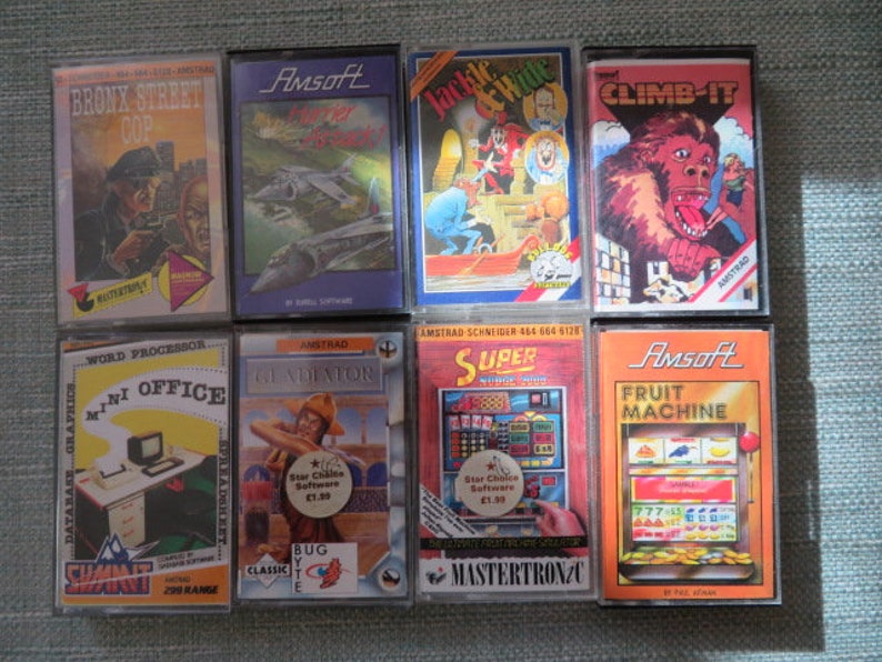 May include: Eight vintage video game cartridges for the Amstrad CPC computer. The cartridges are arranged in two rows of four. The cartridges are all different colors and have different titles, including "Bronx Street Cop", "Jackle & Hyde", "Climb-It", "Mini Office", "Gladiator", "Super", and "Fruit Machine".