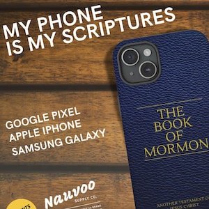 Op de afbeelding: Een marineblauwe telefoonhoes met de gouden tekst "THE BOOK OF MORMON". Ontworpen voor Google Pixel, Apple iPhone en Samsung Galaxy. De afbeelding bevat ook de tekst "MY PHONE IS MY SCRIPTURES".