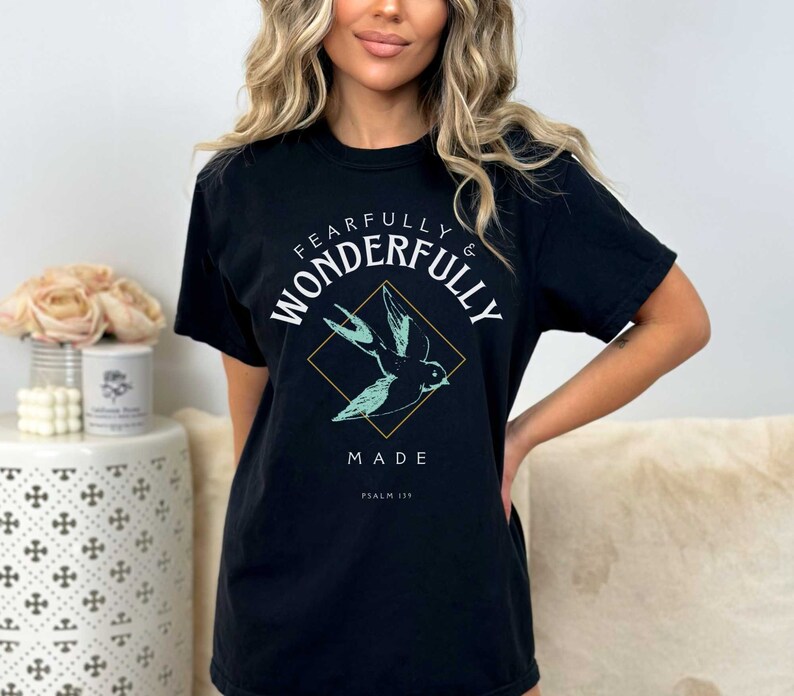 May include: Black t-shirt with a graphic of a bird in flight and the text "Fearfully & Wonderfully Made Psalm 139".