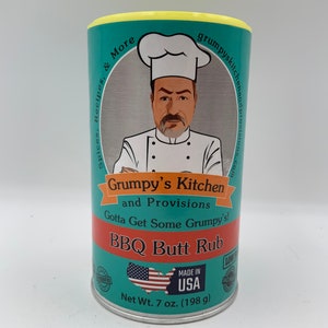 May include: A teal blue can with a yellow lid. The can has a cartoon chef with a white chef's hat and a mustache. The text on the can reads "Grumpy's Kitchen and Provisions Gotta Get Some Grumpy's! BBQ Butt Rub". The can also has a red, white, and blue American flag and the text "Made in USA". The can is 7 ounces (198 grams).