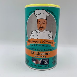 May include: A teal blue can with a yellow lid. The can has a cartoon chef with a mustache and a white chef's hat. The text on the can reads "Grumpy's Kitchen and Provisions Gotta Get Some Grumpy's! Et Etcetera Seasoning Made in USA Net Wt. 6 oz. (170 g)"