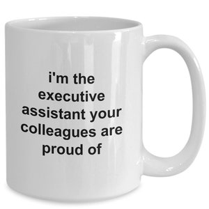 May include: White ceramic coffee mug with black text that reads "i'm the executive assistant your colleagues are proud of"