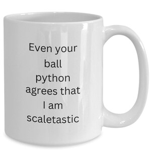 May include: White ceramic coffee mug with black text that reads "Even your ball python agrees that I am scaletastic".