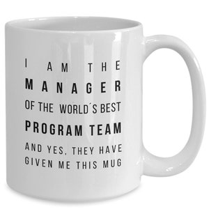 May include: White ceramic coffee mug with black text that reads "I am the Manager of the World's Best Program Team and yes, they have given me this mug."