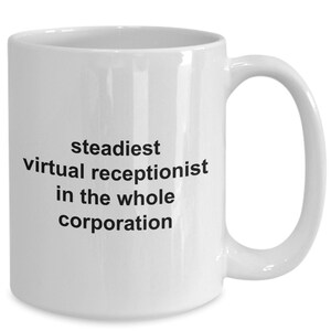 May include: White ceramic mug with a curved handle. The mug features black text that reads "steadiest virtual receptionist in the whole corporation". The mug is designed for hot beverages.