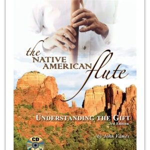 May include: Book cover with a photo of a person playing a Native American flute. The book title is "The Native American Flute: Understanding the Gift, 3rd Edition" by John Vames. The cover also includes a photo of a red rock formation and a CD.