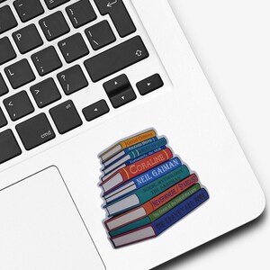 Puede incluir: Una pegatina que muestra una pila de libros coloridos con t&iacute;tulos de Neil Gaiman, incluyendo Good Omens, Anansi Boys, American Gods, Fortunately, the Milk, Coraline, Norse Mythology, The Sandman, Neverwhere, Stardust, The Ocean at the End of the Lane y The Graveyard Book.