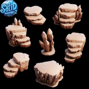 Op de afbeelding: Een verzameling beige, gestileerde rotsformaties en kristalclusters. De set bevat trapsgewijze platforms, trappen en een cluster van kristallen. Het logo voor "Rock Solid Adventures 2" staat linksboven.