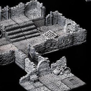 Op de afbeelding: Een gedetailleerde, 3D-geprinte kerkerset in grijs voor tabletop role-playing games. De set bevat een verscheidenheid aan geruïneerde muren, trappen en andere kerkerelementen.