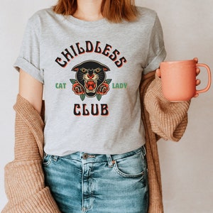 May include: A gray t-shirt with a black panther graphic and the text "Childless Cat Lady Club".