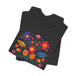 Camiseta "Proteger y defender a los inmigrantes": colorida camiseta de arte popular mexicano con flores. Nadie es ilegal en tierras robadas. Los inmigrantes hacen que Estados Unidos sea grandioso. Dark Grey Heather