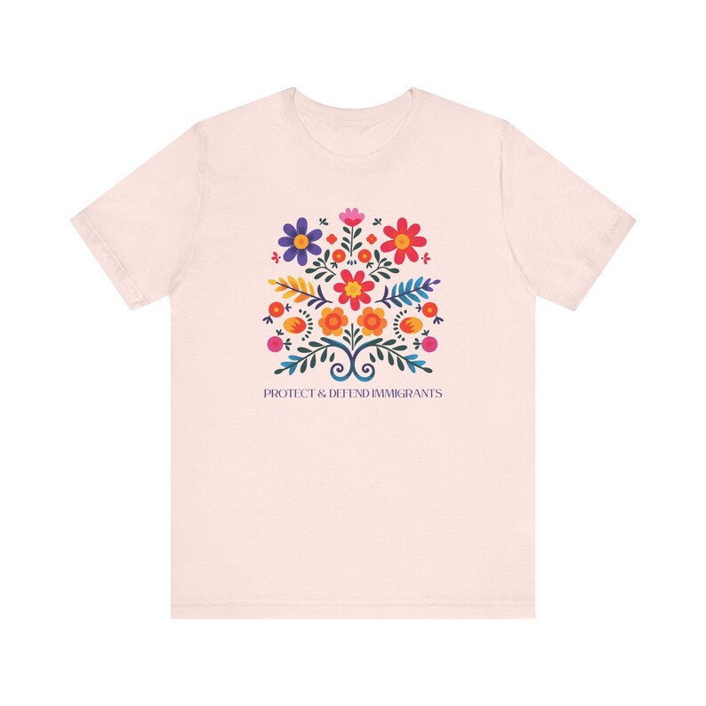 Camiseta "Proteger y defender a los inmigrantes": colorida camiseta de arte popular mexicano con flores. Nadie es ilegal en tierras robadas. Los inmigrantes hacen que Estados Unidos sea grandioso. Soft Pink