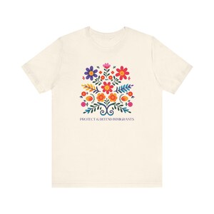 Camiseta "Proteger y defender a los inmigrantes": colorida camiseta de arte popular mexicano con flores. Nadie es ilegal en tierras robadas. Los inmigrantes hacen que Estados Unidos sea grandioso. Natural