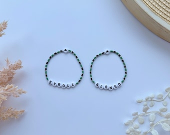 May include: Two beaded bracelets with black and green beads spelling out the names "Stroll" and "Alonso".