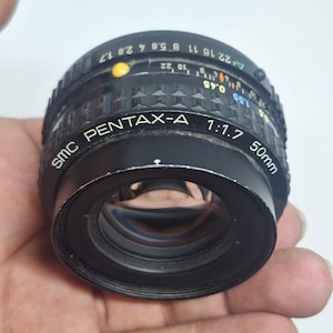 Puede incluir: Una taza de cer&aacute;mica blanca con asa negra y el texto "But First, Coffee" en negrita negra. La taza se encuentra sobre un fondo neutro, resaltando su dise&ntilde;o sencillo.