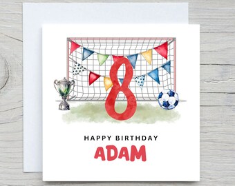 May include: A birthday card with a soccer theme. The card features a red number 8, a soccer ball, a goal, and a trophy. The text "Happy Birthday Adam" is printed on the card.