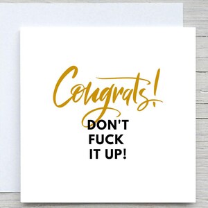 Puede incluir: Una tarjeta de felicitación blanca con la palabra "Congrats!" en letras doradas, seguida del texto "DON'T FUCK IT UP!" en negro y negrita. La tarjeta está dentro de un sobre blanco, perfecta para un mensaje de felicitación.