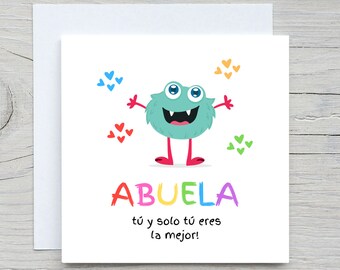 May include: A greeting card with a cartoon monster with blue fur, big eyes, and a toothy grin. The monster is surrounded by hearts in various colors. The card says "ABUELA tú y solo tú eres la mejor!" which translates to "Grandmother, you and only you are the best!"