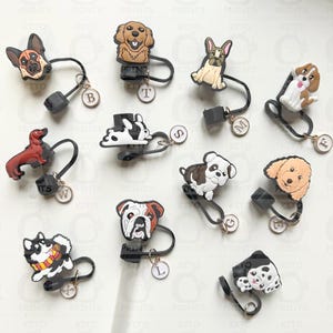 Może przedstawiać: Zestaw 10 czarno-białych zakładek do książek z motywem psów w różnych rasach. Każda zakładka ma czarną plastikową podstawę z metalowym pierścieniem i zawieszką z literą. Wzory psów obejmują buldoga, jamnika, dalmatyńczyka, pudla, buldoga francuskiego, golden retrievera, husky, labradora, beagle'a i terriera.