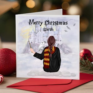 Könnte beinhalten: Weihnachtskarte mit Zauberermotiv. Die Karte zeigt eine Person in schwarzem Umhang und Schal, die einen Zauberstab hält, mit einer Burg und einer Eule im Hintergrund. Der Text "Merry Christmas Sarah" steht oben.