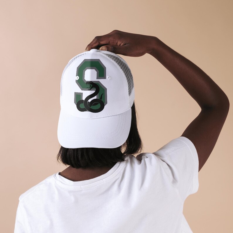 May include: White trucker hat with a green and grey letter 'S' with a black snake inside. The snake is coiled and has its head raised.