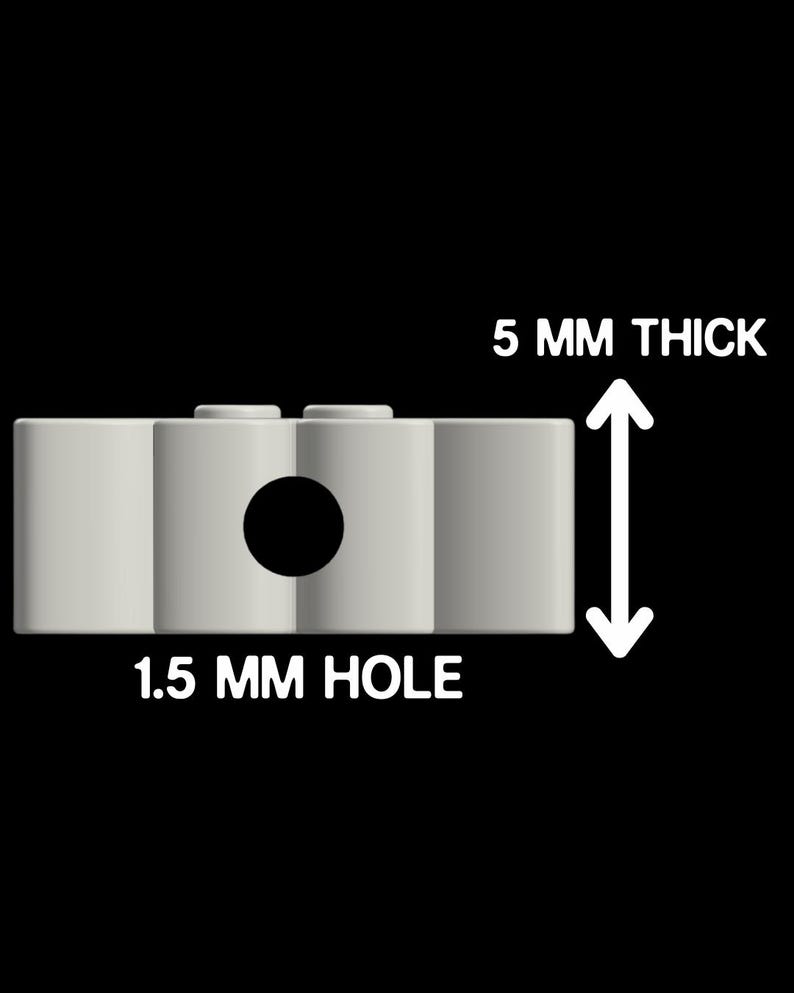May include: A light gray rectangular component featuring a central circular opening and two small studs on the top surface. The object is labeled with text indicating it is 5 mm thick and has a 1.5 mm hole, providing clear technical specifications.