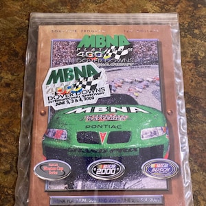 Può includere: Un programma souvenir per le gare MBNA Platinum 200 e 400 al Dover Downs International Speedway. Il programma presenta un'auto da corsa verde con il logo MBNA e le parole "Interstate Batteries" e "Pontiac". Il programma include anche i loghi per la NASCAR Winston Cup Series, NASCAR 2000 e NASCAR Busch Series.