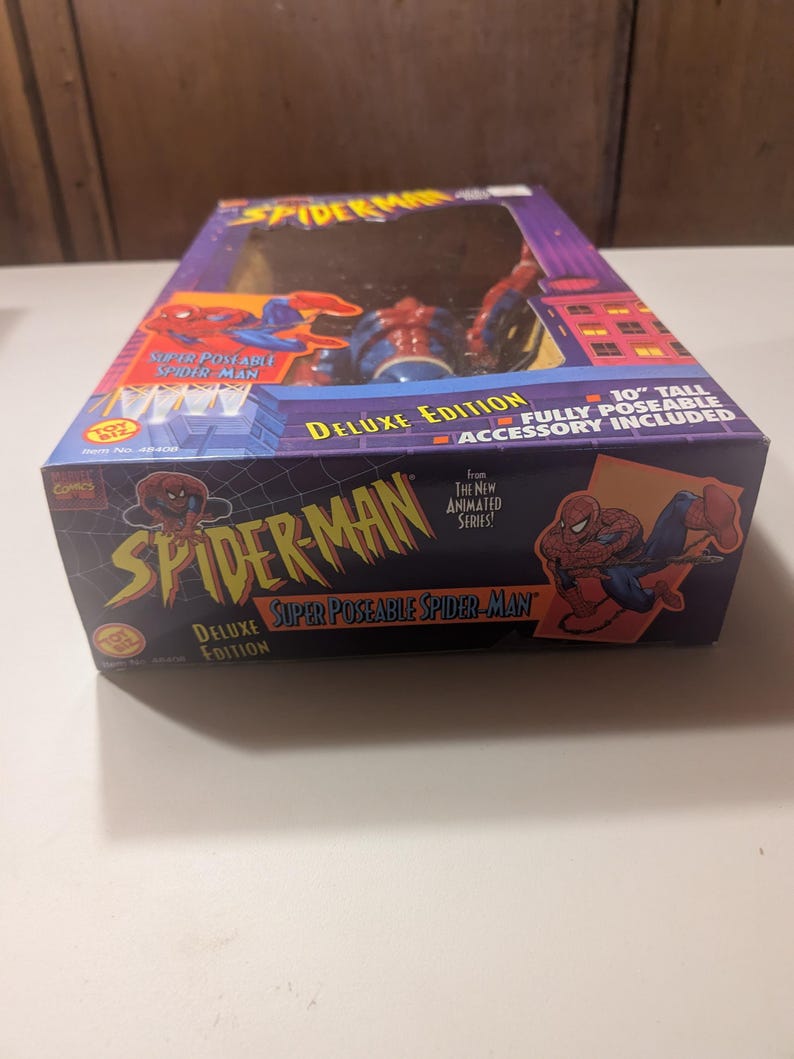 May include: A red and blue Spider-Man action figure in a box. The figure is 10 inches tall and fully poseable. The box features the text "Super Poseable Spider-Man" and "Deluxe Edition".