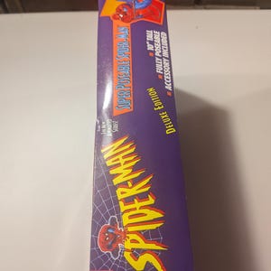 May include: A box for a 10-inch tall, fully poseable Spider-Man action figure. The box is purple with a spider web pattern and features a cartoon image of Spider-Man. The text on the box reads "Super Poseable Spider-Man Deluxe Edition".