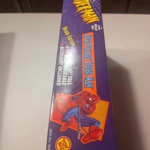 May include: A purple and red box featuring a cartoon image of Spider-Man. The box has the text "Super Poseable Spider-Man" and "Deluxe Edition". The box also includes the text "10" tall poseable accessory included".