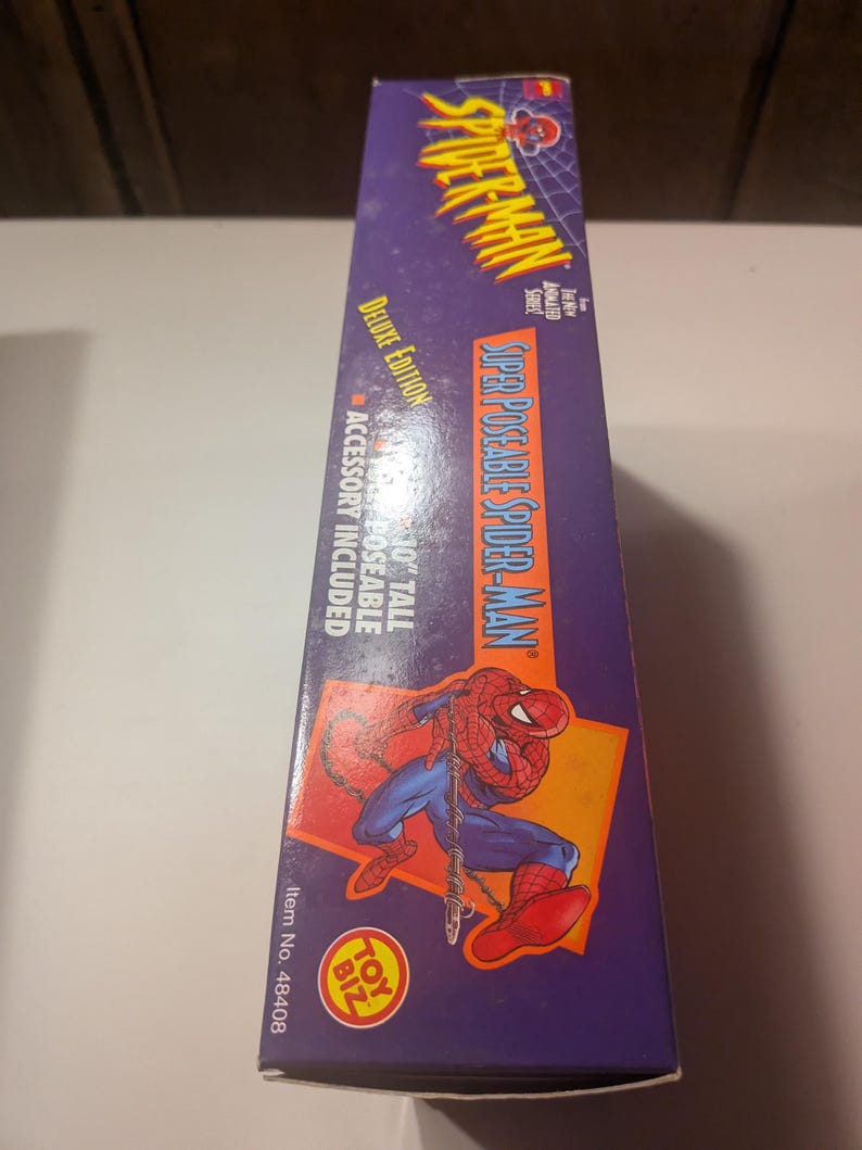 May include: A purple and red box featuring a cartoon image of Spider-Man. The box has the text "Super Poseable Spider-Man" and "Deluxe Edition". The box also includes the text "10" tall poseable accessory included".