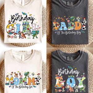 May include: Four t-shirts with birthday-themed designs. Two are off-white, and two are charcoal gray. Each shirt features colorful text and cartoon characters. The shirts read "Birthday Girl", "Daddy Of The Birthday Boy", "Mommy Of The Birthday Girl", and "Birthday Boy".