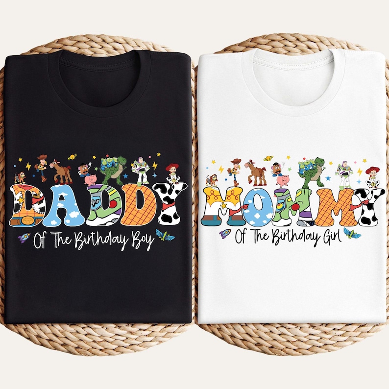 May include: Two t-shirts, one black and one white, with colorful text and cartoon character designs. The black shirt says "DADDY Of The Birthday Boy." The white shirt says "MOMMY Of The Birthday Girl."