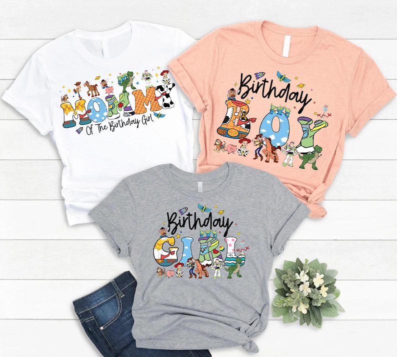 May include: Three t-shirts with colorful graphics. The white shirt says "Mommy of The Birthday Girl". The peach shirt says "Birthday Boy". The gray shirt says "Birthday Girl". All shirts have cartoon character designs.