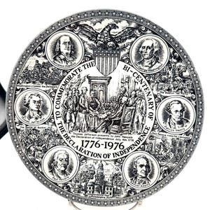 May include: A commemorative plate celebrating the bicentennial of the Declaration of Independence, 1776-1976. The black and white plate features portraits of historical figures, illustrations of key events, and the text "To Commemorate the Declaration of Independence."