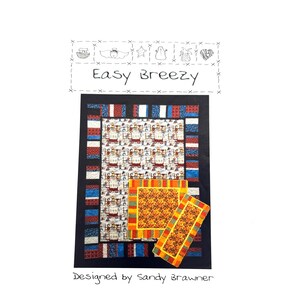 May include: A quilt pattern called "Easy Breezy" designed by Sandy Brawner. The quilt features a patchwork design with red, white, and blue fabric. The quilt is surrounded by a black border.