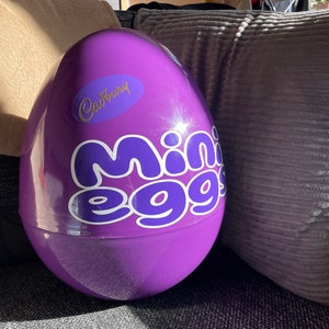 Op de afbeelding: Een groot paars plastic ei met het Cadbury-logo en de tekst "Mini Eggs" erop gedrukt.