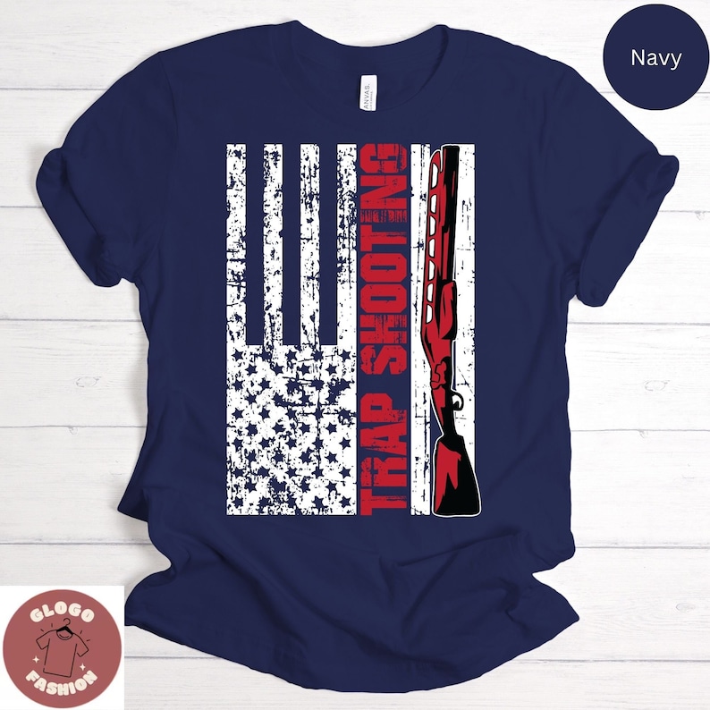 May include: A navy blue t-shirt with a distressed American flag design and a red shotgun with the text "TRAP SHOOTING" in red.